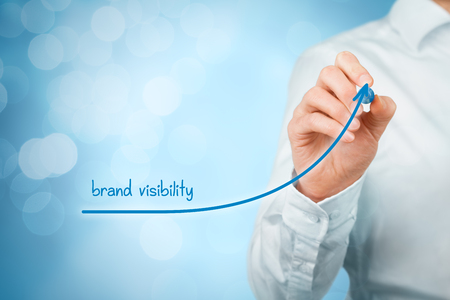 Brand visibility improvement concept. Brand manager (marketing specialist) draw growing graph with text brand visibility.の写真素材