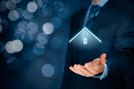 Property insurance and security concept. Protecting gesture of man and symbol of house.の写真素材