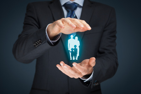 Family life insurance, family services and supporting families concepts. Businessman with protective gesture and silhouette representing young family.の写真素材