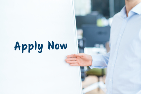 Apply now concept. Businessman (recruiter, HR staffer) attract new employees on company presentation.の写真素材