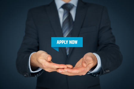 Businessman or manager hold virtual label with text Apply now - human resources concept.の写真素材