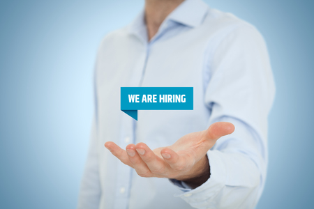 Headhunter (recruiter) hold virtual label with text we are hiring - human resources concept.の写真素材