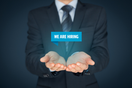 Headhunter (recruiter) hold virtual label with text we are hiring - human resources concept.の写真素材