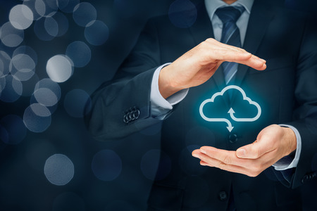 Cloud computing security concept - connect devices to cloud. Businessman or information technologist with cloud computing icon and protective gesture.の写真素材