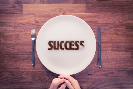 Leadership is hungry for success. Motivational concept. Businessman with plate and cookies with text success.の写真素材