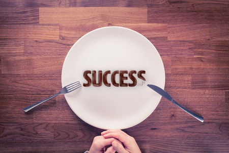 Leadership is hungry for success. Motivational concept. Businessman with plate and cookies with text success.の写真素材
