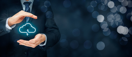 Cloud computing security concept - connect devices to cloud. Businessman or information technologist with cloud computing icon and protective gesture.の写真素材