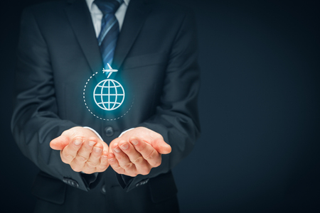 Travel insurance and business travel concepts. Insurance agent or businessman with protective gesture and icon of plane and globe.の写真素材