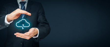 Cloud computing security concept - connect devices to cloud. Businessman or information technologist with cloud computing icon and protective gesture.の写真素材
