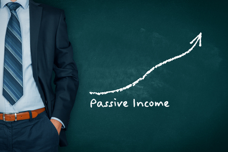 Passive income concept. Businessman with hands in passive gesture and increasing graph with text passive income.の写真素材