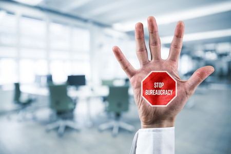 Stop bureaucracy concept. Businessman hand with stop street sign and text Stop Bureaucracy.の写真素材