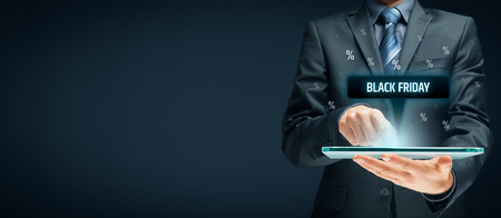 Black Friday sale concept. Businessman click on tablet on black Friday button, percentages on background.の写真素材