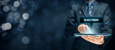 Black Friday sale concept. Businessman click on tablet on black Friday button, percentages on background.の写真素材
