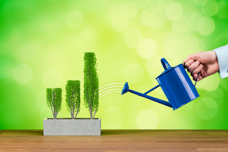 Successful business growth concept. Businessman is watering graph, symbol of business growth.の写真素材