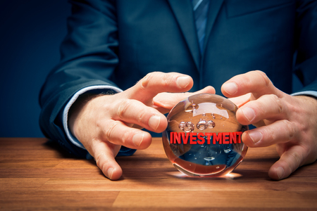 Investment prediction and planning. Look into the crystal ball. Investor visionary with crystal ball and text investment.の写真素材