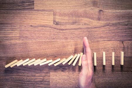 Risk management concept. Risk manager (or another business person) has problem solution. Businessman stop domino effect, top view.の写真素材