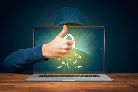 Notebook password protection by antivirus and cyber security concept. Hacker with positive gesture with thumb up praise user for protected computer and its data.の写真素材
