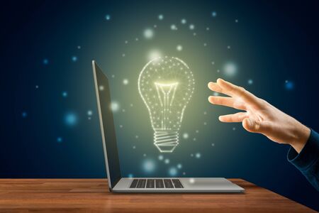 Creativity, idea and artificial intelligence concepts. Hands with notebook and graphics light bulb - symbols of idea, creative thinking, innovations and artificial intelligence (AI).の写真素材