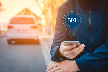 Taxi searching on smart phone concept. Smart phone user is looking for taxi service outside.の写真素材