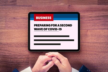 Preparing for a second wave of covid-19 in business news. Businessman read how to prepare company for a second wave of coronavirus covid-19. Post-covid-19 era in business and investment concept.の写真素材