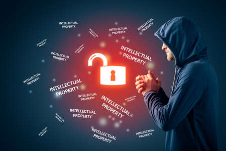 Malicious hacker prepared to steal corporate intellectual property. Corporate company data leakage and bad security concept.の写真素材