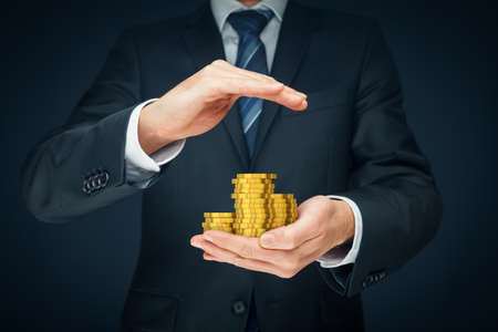 Protect investments and savings, financial insurance concept. Businessman hand with protective gesture and coins of money.の写真素材