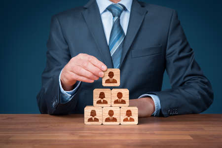 Human resources, corporate hierarchy concept and multilevel marketing - recruiter complete team represented by wooden cube by one leader person (CEO) and icon.の写真素材