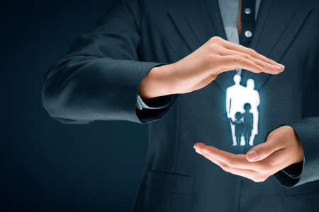 Family life insurance, family services and supporting families concepts. Businesswoman with protective gesture and silhouette representing young insured family.の写真素材