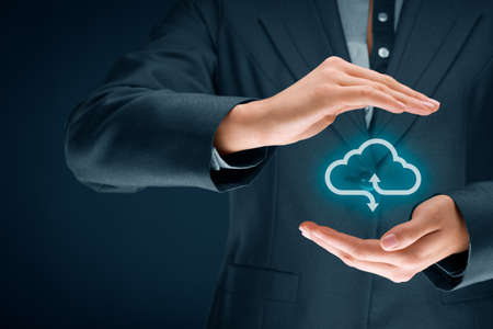 Cloud computing security concept - connect devices to cloud. Businesswoman or information technologist with cloud computing icon and protective gesture.の写真素材