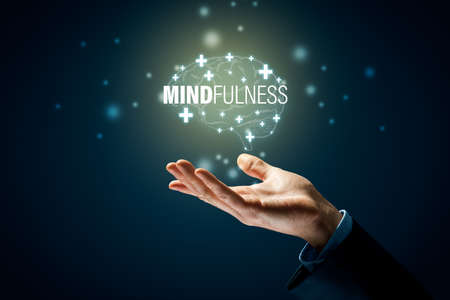 Mindfulness is key for mental and physical health. Hand with symbol of brain and text mindfulness.の写真素材