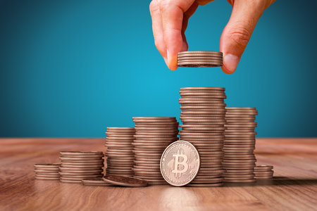 Bitcoin cryptocurrency save money concept.  Hand with Bitcoin coins giving on mound of Bitcoins. 

Concept of buy, sell, saving, or theft.の写真素材
