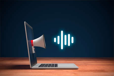 Podcast or music listening concept with megaphone and notebook. Computer on wooden table, megaphone and symbol of podcast.の写真素材
