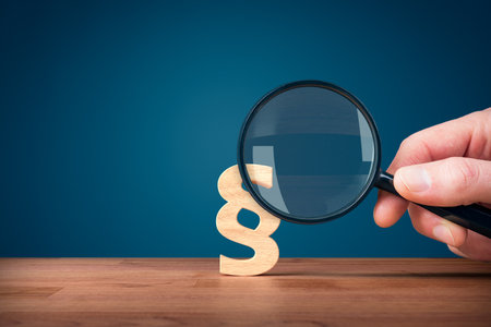Lawyer and advocate services concept. Hand holding magnifying glass enlarge symbol of paragraph.の写真素材