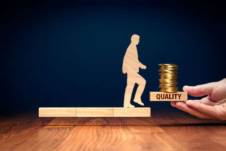 Quality improvement means improving revenue concept. Wooden person on wooden blocks and helping hand with block with text quality and coins.の写真素材