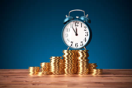 Time is money concept. It is five minutes to twelve for good investment concept. Alarm clock and coins.の写真素材