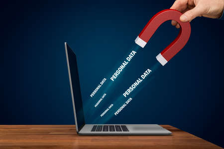 Unprotected personal data attracted by magnet concept. Hand with magnet, open notebook and personal data flying to the magnet.の写真素材
