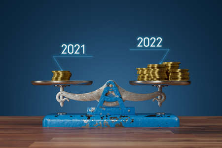 Inflation concept with scales and coins. In 2022, the same thing can be bought for more money than in 2021. Inflation is devaluation of savings.の写真素材