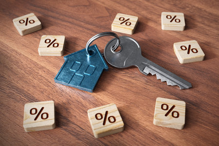 The key to your own home is to get a mortgage. Key with house shaped key ring. Wooden cubes with percentage symbol representing mortgage.の写真素材