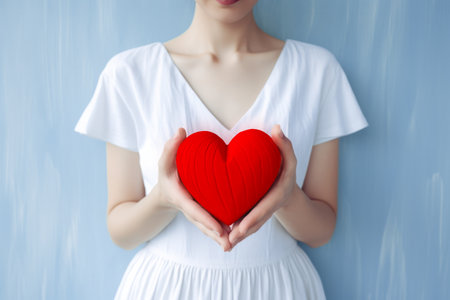 Heart healthcare concept, cardiology and love concepts. Woman in white dress holding in hands red wooden symbol of heart. Love your heart concept. Generated with the use of an AI.の素材