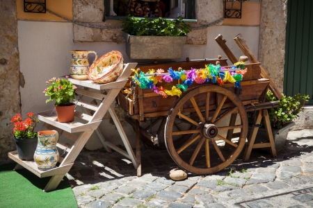 typical portuguese ceramics and small old wooden cart at the doors of a craft shop in Lisbon, Portugalの写真素材