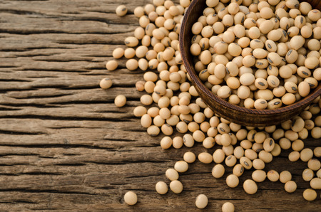 Soybean in wood bowl on wooden background.