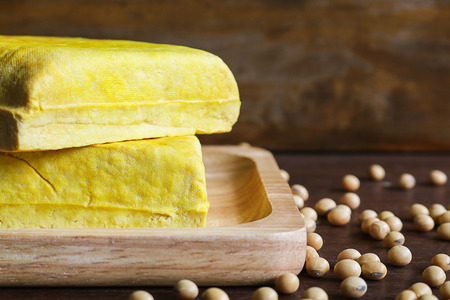 yellow tofu and soybeans, Vegetarian food on wooden dish. tofu made from soybean is naturally...