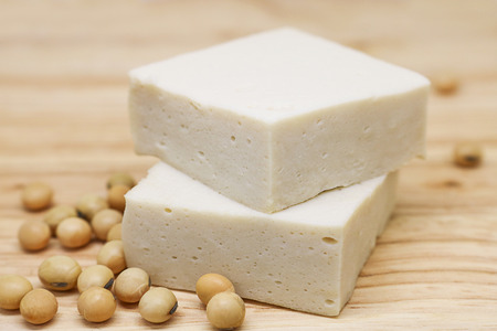 soy tofu or bean curd, vegetarian food on wooden background. tofu made from soybean is naturally gluten-free and low calorieの写真素材