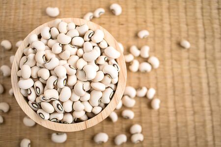Black eyed beans in wooden bowl on reed mat. Black eyed peas has health benefits, Good for helps weight loss and relieving constipation.の写真素材