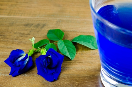 Asian pigeonwings and blue juice isolated on wood backgroundの写真素材