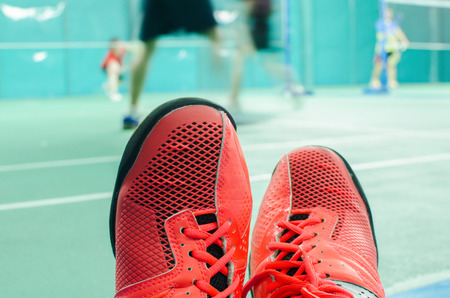 Red sport shoes with player in court