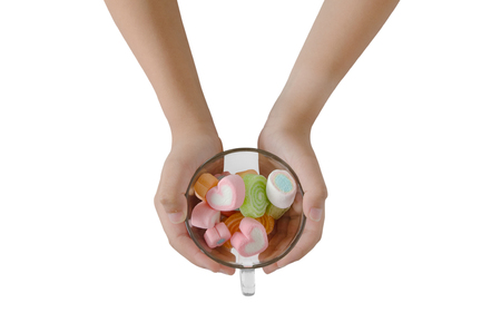 Child hand on jellys in cup on white backgroundの写真素材
