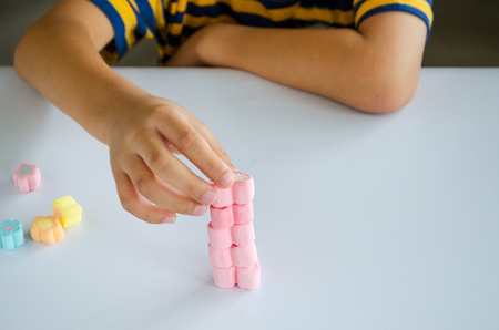 Child hands play jellys on white tableの写真素材