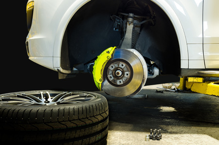 Car mechanic changing tire in professional car repair serviceの写真素材