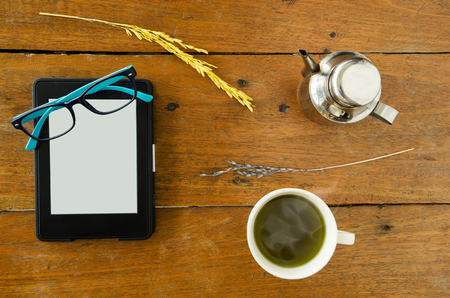 E-Book, E-reader With Glasses And Hot Green Tea On Wood Table. Top Views.の写真素材